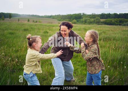 Eine Mutter zerbricht die Kinder, die im Regen auf dem Feld kämpfen Stockfoto