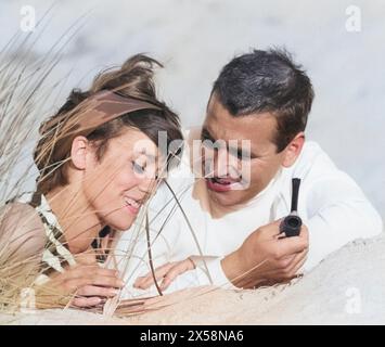 Leute, Paare, Liebende, junge Paare, die am Strand liegen und miteinander reden, 1960er Jahre, EXTRA-RIGHTS-CLEARANCE-INFO-NOT-AVAILABLE Stockfoto