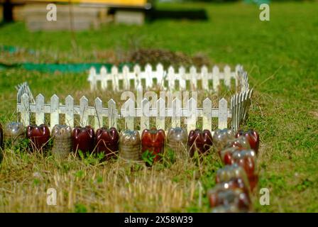 Zaun für ein Blumenbeet aus Plastikflaschen im Garten, Russland Stockfoto