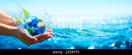 Ocean Environment Concept - Hände halten Globe Glass in blauem Meer mit unscharfen Lichtern - enthalten 3D-Rendering - Elemente dieser Bilder bereitgestellt von Stockfoto