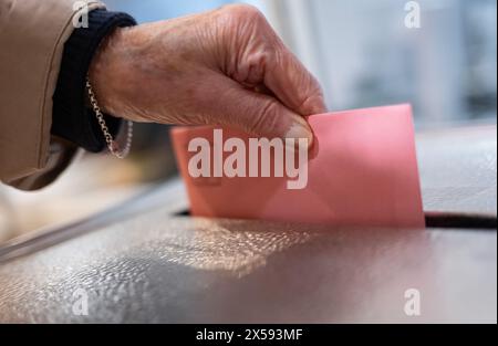 Stuttgart, Deutschland. Mai 2024. Eine Wählerin wirft ihre Stimmzettel in eine Wahlurne in einem Wahlhaus im Rathaus der Landeshauptstadt Baden-Württemberg. Am 9. Juni 2024 finden die Europa- und Kommunalwahlen statt. Die Wähler können ihre Stimmen bereits per Post abgeben. Quelle: Marijan Murat/dpa/Alamy Live News Stockfoto