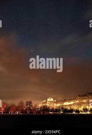 Beynac-et-Cazenac, Frankreich - 6. Mai 2024: Einbruch der Dunkelheit über dem Chateau de Beynac in der Region Dordogne in Frankreich mit Lichtspuren von Autos im Vorland Stockfoto