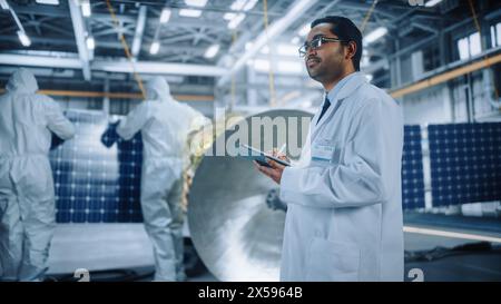 Team von Ingenieuren arbeitet an Satellite Construction, Wissenschaftler verwendet Tablet Computer. Aerospace Agency: Diverse Gruppe von Spezialisten, die Raumfahrzeuge für Weltraumforschungsmissionen entwickeln Stockfoto