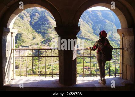 Weibliche Reisende am zweibogigen Portico der Kirche der Himmelfahrt in Vardzia Medieval Cave City auf dem Erusheti Mountain, Südgeorgien Stockfoto