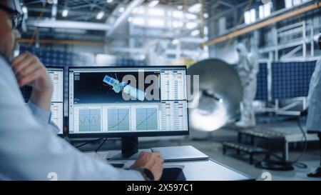 Team von Ingenieuren, die an Satellitenbau arbeiten. Aerospace Agency International Space Mission: Verschiedene Wissenschaftler entwickeln Raumfahrzeuge und berechnen die Orbitalbahn am Computer Stockfoto