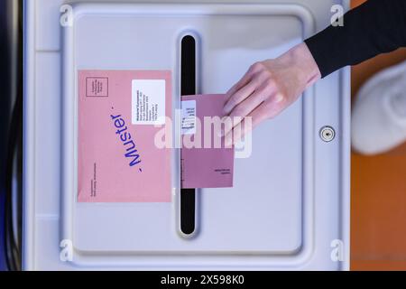 Leipzig, Deutschland. Mai 2024. Eine Frau lässt den Umschlag mit dem Stimmzettel für die Europawahlen in eine Wahlbox im neuen Postwahlamt im Leipziger Rathaus fallen. Die Bürger können hier dienstags und donnerstags zwischen 9.00 und 18.00 Uhr, mittwochs zwischen 9.00 und 16.00 Uhr und freitags zwischen 9.00 und 14.00 Uhr vor dem eigentlichen Wahlsonntag ihre Stimme abgeben. Neben den Europawahlen werden am 9. Juni auch Kommunalwahlen in Sachsen stattfinden. Quelle: Jan Woitas/dpa/Alamy Live News Stockfoto