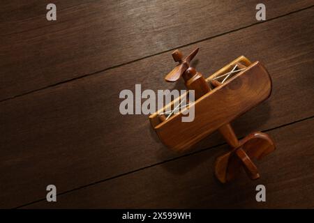 Draufsicht eines Holzspielzeugflugzeugs auf einem Holztisch im Hintergrund Stockfoto