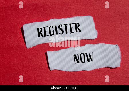 Jetzt registrieren Wörter auf gerissenen weißen Papierstücken mit rotem Hintergrund. Symbol „jetzt registrieren“. Kopierbereich. Stockfoto