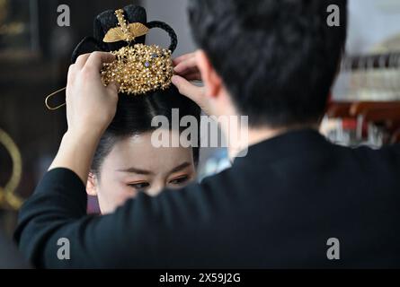 (240508) -- TIANJIN, 8. Mai 2024 (Xinhua) -- Ma Sai überträgt ein filigranes Mosaikkunstwerk auf den Kopf eines Hanfu-Enthusiasten in seinem Atelier im Dorf Liuzhuang im Bezirk Wuqing in Tianjin, Nordchina, 7. März 2024. MA's filigrane Mosaic Art, ein immaterielles Kulturerbe der Stadt in Tianjin, zog die Aufmerksamkeit des ganzen Landes auf sich, als ein damit hergestelltes Accessoire während der Frühlingsfestgala des Jahres des Drachen, die vom chinesischen Zentralfernsehen inszeniert wurde, auf den Kopf einer chinesischen Schauspielerin erschien. auch CCTV genannt. Filigrane Mosaikkunst, erstmals in der Frühlings- und Herbstzeit (770 v. Chr.- Stockfoto