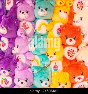 tokio, japan - 16. april 2024: Eine Gruppe von Vibrant Care Bears Plushies, die jeweils mit liebenswerten Bauchtüchern wie Herzen, Sonnen, Cupcakes und Moo verziert sind Stockfoto