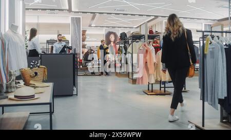 Bekleidungsgeschäft: Verschiedene Gruppen von Kunden, die am Kassenschalter einkaufen, Kleidung und Waren kaufen. Retail Fashion Shop Assistant Hilft Kunden Beim Verkauf Stilvoller Designermarken. Stockfoto