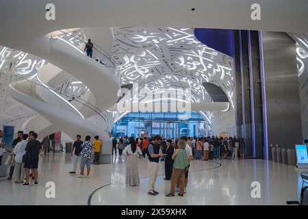 Dubai, VAE - 16. Januar 2024: Eintritt zum Museum der Zukunft, Innenraum der Eingangshalle mit Wendeltreppen und Touristen. Stockfoto