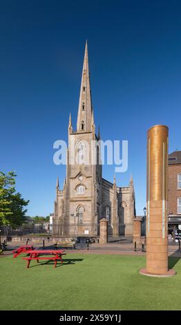 Republik Irland, County Monaghan, Stadt Monaghan, Church Square, St. Patrick's Church of Ireland mit dem Monaghan Memorial, einer Sandstein- und Metallsäule, die vor dem Gericht errichtet wurde, um an die sieben Menschen zu erinnern, die von Loyalisten beim Bombenanschlag in Monaghan am 17. Mai 1974 getötet wurden. Stockfoto