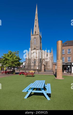 Republik Irland, County Monaghan, Stadt Monaghan, Church Square, St. Patrick's Church of Ireland mit dem Monaghan Memorial, einer Sandstein- und Metallsäule, die vor dem Gericht errichtet wurde, um an die sieben Menschen zu erinnern, die von Loyalisten beim Bombenanschlag in Monaghan am 17. Mai 1974 getötet wurden. Stockfoto