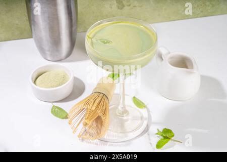 Cremiger Matcha-Martini-Cocktail Matchatini, trendiger kalter Sommercocktail. Matcha alkoholfreier Mocktail oder Alkohol Cocktail, in Martini Gläsern mit GREE Stockfoto