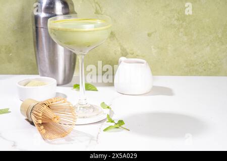 Cremiger Matcha-Martini-Cocktail Matchatini, trendiger kalter Sommercocktail. Matcha alkoholfreier Mocktail oder Alkohol Cocktail, in Martini Gläsern mit GREE Stockfoto