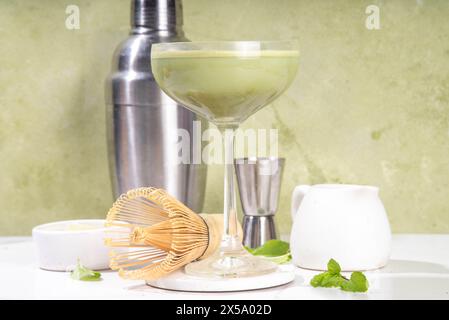 Cremiger Matcha-Martini-Cocktail Matchatini, trendiger kalter Sommercocktail. Matcha alkoholfreier Mocktail oder Alkohol Cocktail, in Martini Gläsern mit GREE Stockfoto