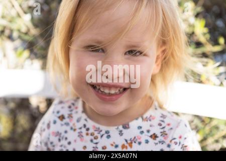 Lächelndes Mädchen Porträt, 3 Jahre alte kaukasische blonde Tochter posiert für Porträt Stockfoto
