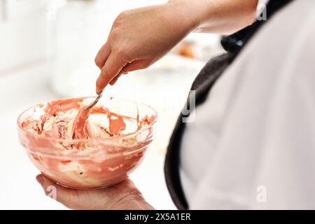 Baker, Schüssel und Hände mit Dessert in der Bäckereiküche zum Essen von Snacks, Puderzucker und Kochen für den Kuchenladen. Zuckerguss, Glasbehälter und Koch Stockfoto