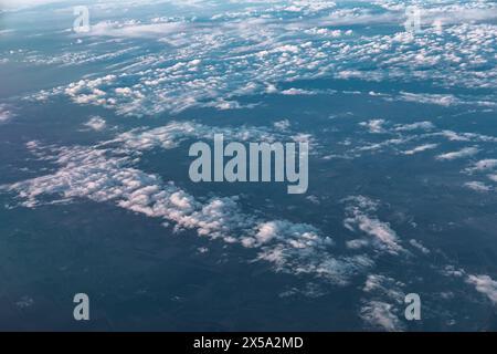 Wolken und Himmel über der Erde wie durch das Fenster eines Flugzeugs gesehen, Blick von oben Stockfoto