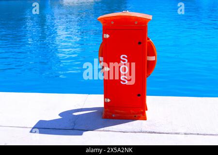 Roter Rettungsring am Wasserrand mit Text SOS Stockfoto