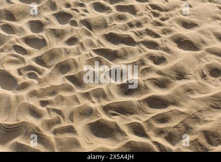 Hintergrund von trockenem Sand, wo Wellen zuvor ein Wellenmuster erzeugt haben Stockfoto