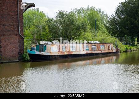 Altes, rostiges und möglicherweise verlassenes Schmalboot, das am Ellesmere Arm des Llangollen Canal in Shropshire vertäut ist. Stockfoto