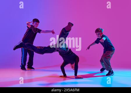 Tanzkämpfe. Tänzer mit beeindruckendem Kopfstand, Breakdance bewegt gemischtes Neonlicht vor einem lebendigen Hintergrund mit Farbverlauf. Stockfoto