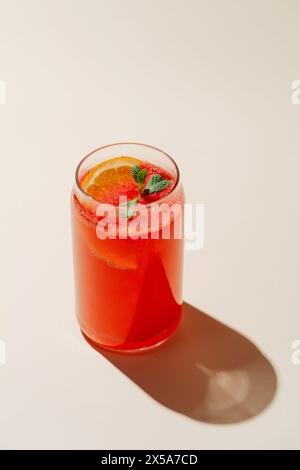 Lebendige Beeren-Orange-Limonade im Glas, garniert mit frischer Minze und einer Scheibe Orange, perfekt für einen heißen Tag. Stockfoto