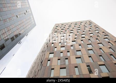 Blick nach oben auf moderne Hochhäuser vor bewölktem Himmel Stockfoto