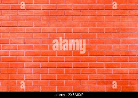 Hochauflösendes Bild mit nahtloser Textur einer orangen Ziegelwand, perfekt für den Hintergrund oder Designelemente. Stockfoto