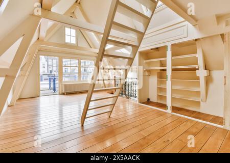 Ein minimalistischer Dachboden mit Holzfußboden, weißen Wänden und viel Tageslicht durch mehrere Fenster. Stockfoto