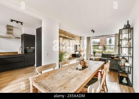 Helles und luftiges, modernes Apartment mit offenem Grundriss, Esstisch aus Holz, elegantem Wohnbereich und eleganter Küche. Stockfoto