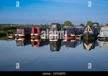 Dunchurch Pools Marina, Warwickshire, Oxford Canal – Schmalboote am Sommermorgen in ruhiger Umgebung vor einem klaren blauen Himmel Stockfoto