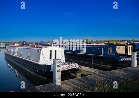 Dunchurch Pools Marina, Warwickshire, Oxford Canal – Schmalboote am Sommermorgen in ruhiger Umgebung vor einem klaren blauen Himmel Stockfoto