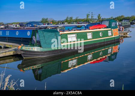 Dunchurch Pools Marina, Warwickshire, Oxford Canal – Schmalboote am Sommermorgen in ruhiger Umgebung vor einem klaren blauen Himmel Stockfoto