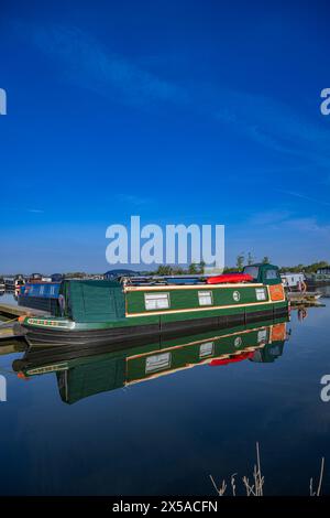 Dunchurch Pools Marina, Warwickshire, Oxford Canal – Schmalboote am Sommermorgen in ruhiger Umgebung vor einem klaren blauen Himmel Stockfoto