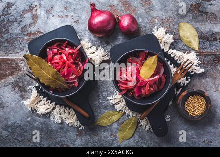 Eingelegte rote Zwiebeln in Schüssel auf grauem Hintergrund. Vorspeise, Würze oder Topping, gesunde fermentierte Lebensmittel. Stockfoto