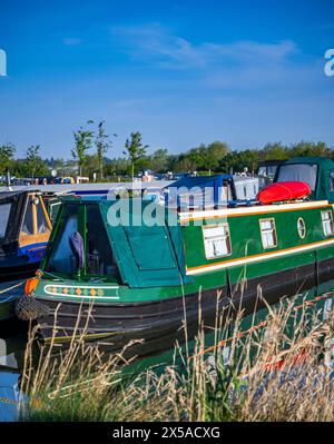 Dunchurch Pools Marina, Warwickshire, Oxford Canal – Schmalboote am Sommermorgen in ruhiger Umgebung vor einem klaren blauen Himmel Stockfoto