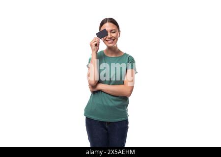 Junge schwarzhaarige Frau in einem einfachen T-Shirt mit Kreditkarte Stockfoto