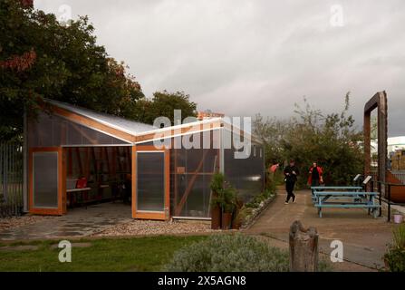 Vordere Höhe der lichtdurchlässigen Eingangsfassade mit offener Tür, Studenten kommen an. Cody Dock - The Growing Space, London, Großbritannien. Architekt: Li Stockfoto