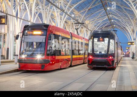 Lodz, Polen. Zwei moderne Straßenbahnen an der Straßenbahnhaltestelle Piotrkowska Centrum am Abend Stockfoto