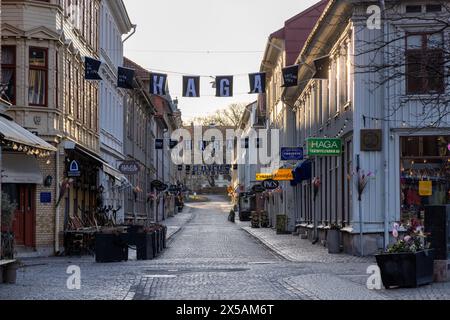 Göteborg, Schweden - 9. April 2023: Handelsstraße mit Schildern und Geschäften am frühen Morgen bei Sonnenaufgang. Keine sichtbaren Personen Stockfoto