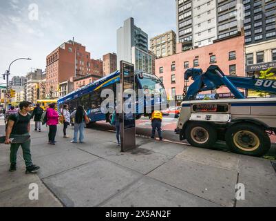 Ein Arbeiter bereitet sich darauf vor, am Montag, den 6. Mai 2024, einen behinderten NYCTA-Bus in Chelsea in New York abzuschleppen. (© Richard B. Levine) Stockfoto