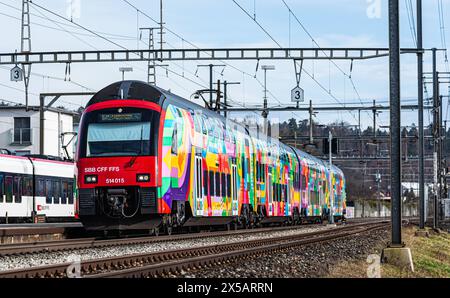 Eine Zürcher S-Bahn der Linie S24 (S-Bahn 24) vom Typ SBB Rabe 514 fährt in den Bahnhof Bassersdorf ein. Der Zug trägt die ZVV-Werbung mit dem Titel ' Stockfoto