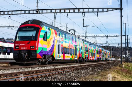 Eine Zürcher S-Bahn der Linie S24 (S-Bahn 24) vom Typ SBB Rabe 514 fährt in den Bahnhof Bassersdorf ein. Der Zug trägt die ZVV-Werbung mit dem Titel ' Stockfoto