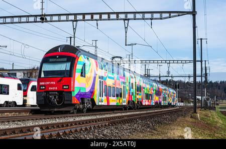 Eine Zürcher S-Bahn der Linie S24 (S-Bahn 24) vom Typ SBB Rabe 514 fährt in den Bahnhof Bassersdorf ein. Der Zug trägt die ZVV-Werbung mit dem Titel ' Stockfoto