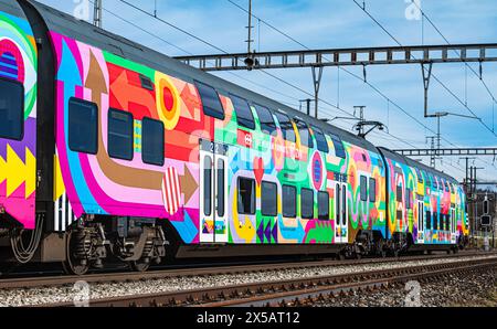 Eine Zürcher S-Bahn der Linie S24 (S-Bahn 24) vom Typ SBB Rabe 514 fährt in den Bahnhof Bassersdorf ein. Der Zug trägt die ZVV-Werbung mit dem Titel ' Stockfoto