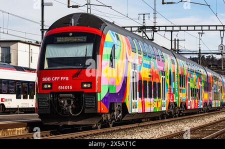 Eine Zürcher S-Bahn der Linie S24 (S-Bahn 24) vom Typ SBB Rabe 514 fährt in den Bahnhof Bassersdorf ein. Der Zug trägt die ZVV-Werbung mit dem Titel ' Stockfoto