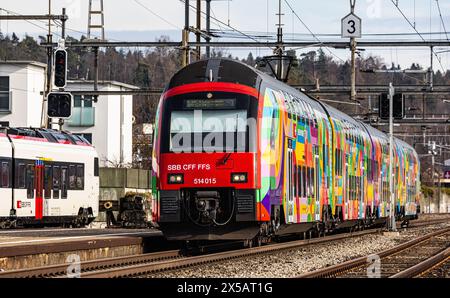 Eine Zürcher S-Bahn der Linie S24 (S-Bahn 24) vom Typ SBB Rabe 514 fährt in den Bahnhof Bassersdorf ein. Der Zug trägt die ZVV-Werbung mit dem Titel ' Stockfoto